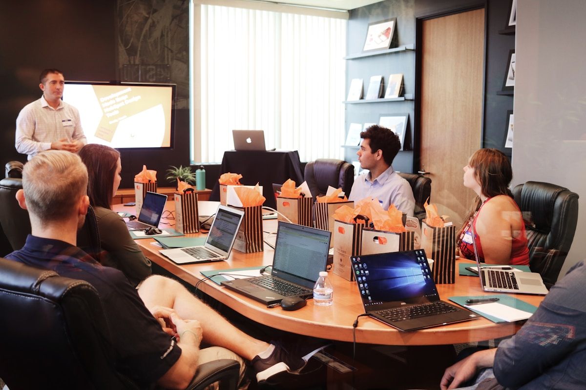 Business team in meeting with laptops — AI meeting assistant integration