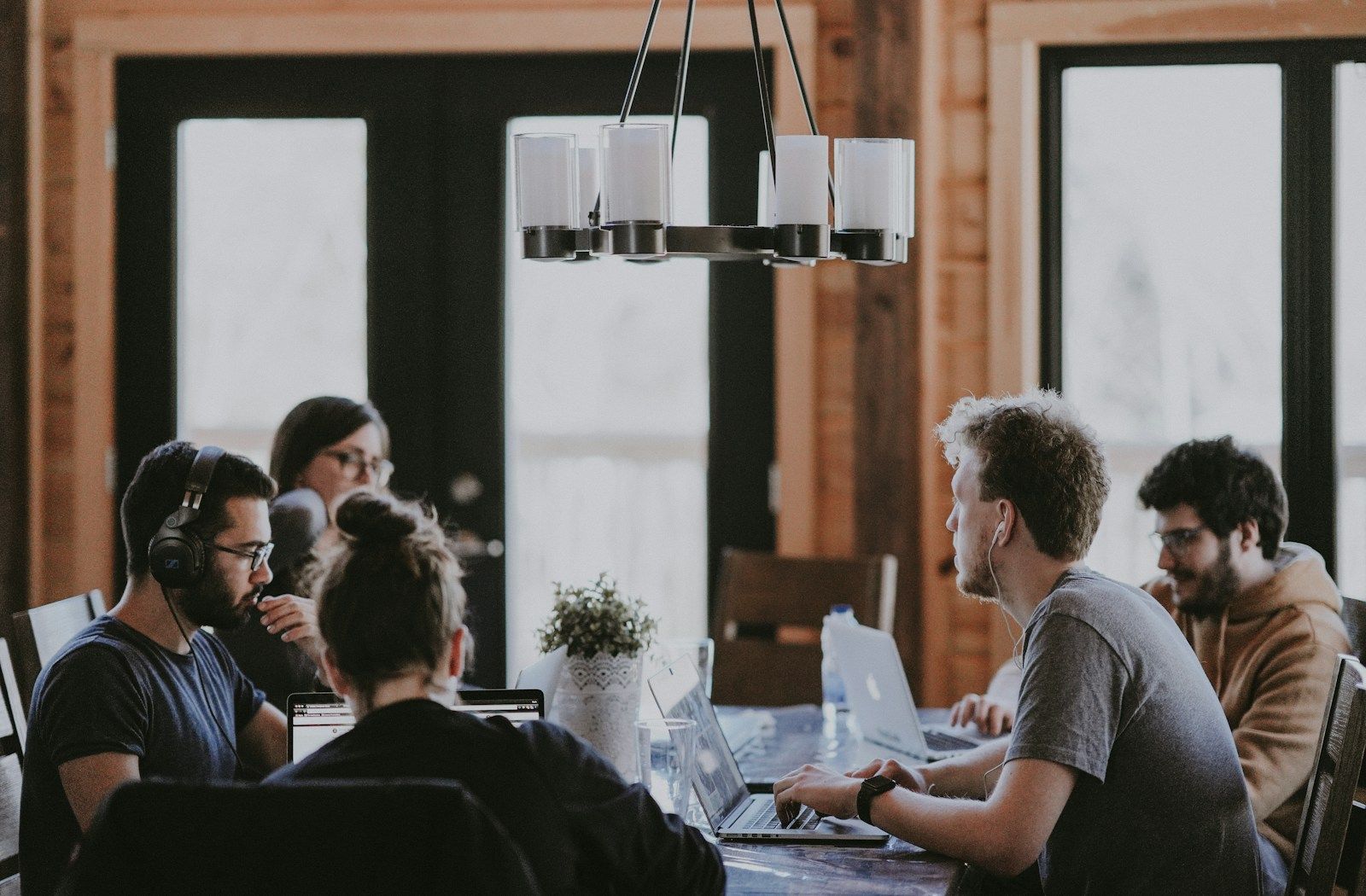Team collaborating on laptops during a meeting while using an AI meeting assistant